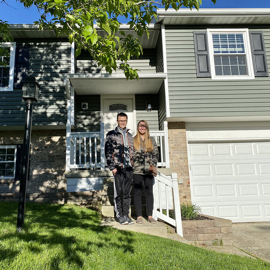 First-time homebuyers standing in front of their new home in Columbus, Ohio