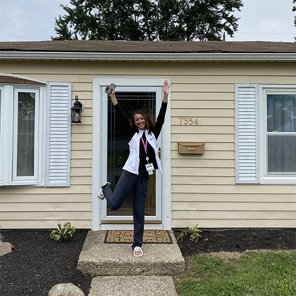 Homeowner in front of her new home